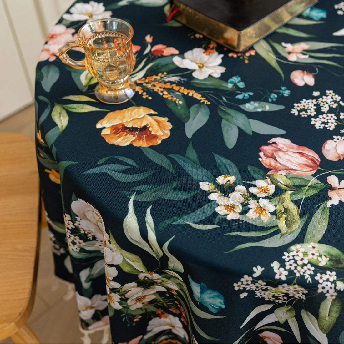 Elegant Dark Floral Round Tablecloth – Add a touch of sophistication to your dining area with this round tablecloth featuring a rich dark green background adorned with vibrant floral prints in shades of orange, pink, and white. Finished with delicate white tassels, it combines elegance with charm, making it perfect for everyday meals, tea parties, or special gatherings. Durable and stylish, it complements both modern and classic home décor.
