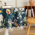 Elegant Dark Floral Round Tablecloth – Add a touch of sophistication to your dining area with this round tablecloth featuring a rich dark green background adorned with vibrant floral prints in shades of orange, pink, and white. Finished with delicate white tassels, it combines elegance with charm, making it perfect for everyday meals, tea parties, or special gatherings. Durable and stylish, it complements both modern and classic home décor.
