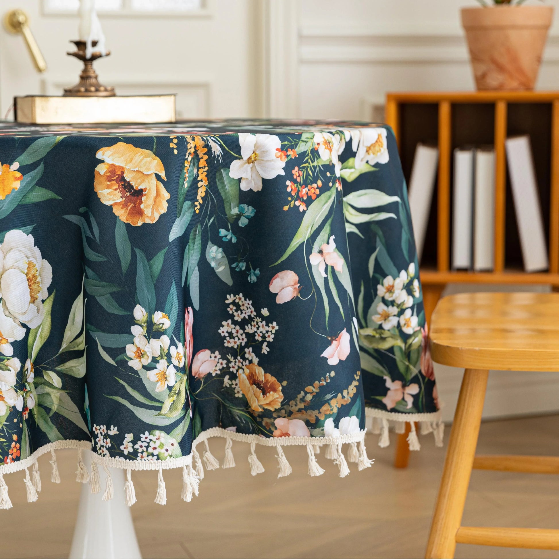 Elegant Dark Floral Round Tablecloth – Add a touch of sophistication to your dining area with this round tablecloth featuring a rich dark green background adorned with vibrant floral prints in shades of orange, pink, and white. Finished with delicate white tassels, it combines elegance with charm, making it perfect for everyday meals, tea parties, or special gatherings. Durable and stylish, it complements both modern and classic home décor.
