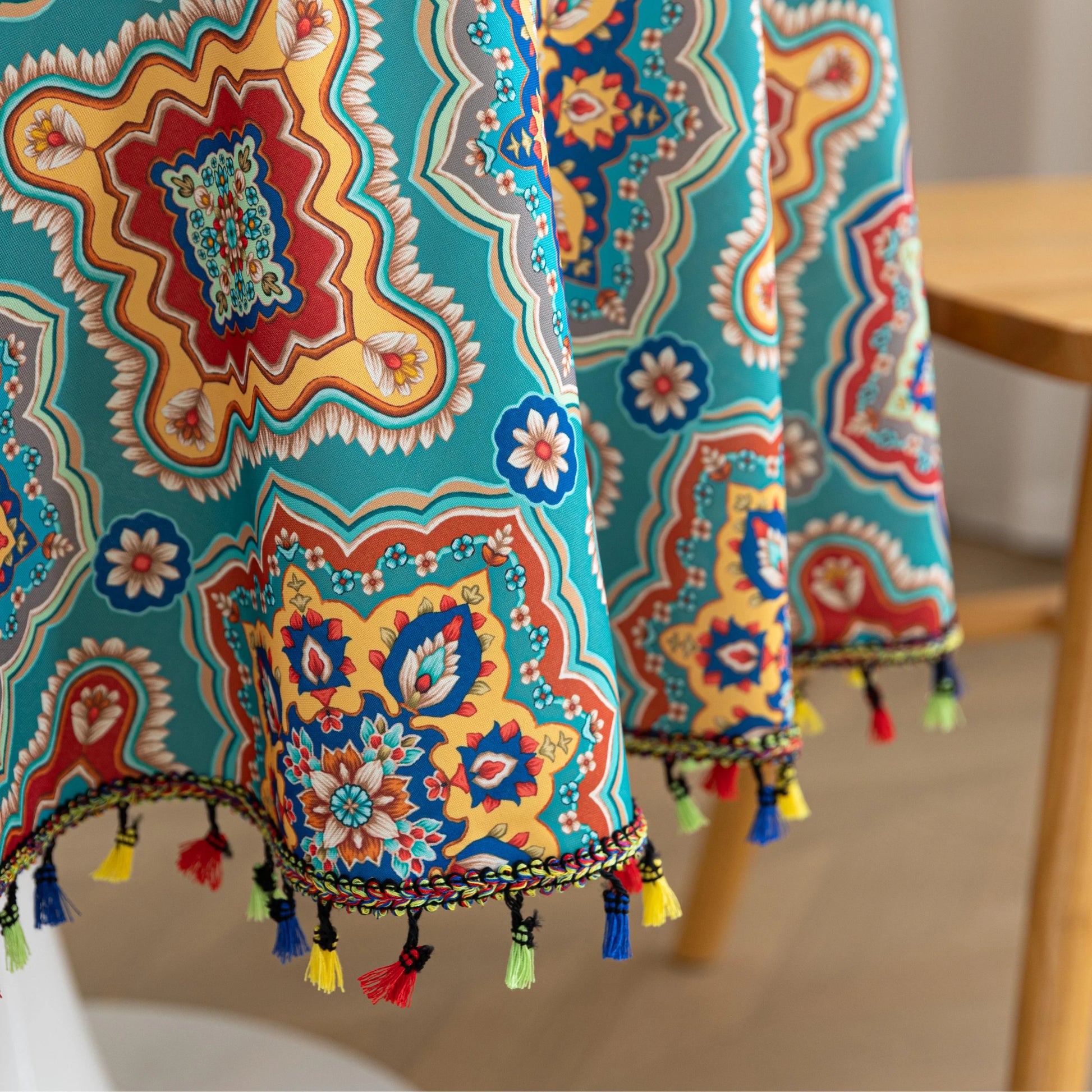Bohemian Round Tablecloth – Add vibrant charm to your dining area with this colorful round tablecloth featuring intricate Moroccan-inspired patterns in bold turquoise, red, and yellow hues. Finished with playful multicolor tassels along the edge, it brings a lively boho flair to both indoor and outdoor dining. Perfect for kitchen tables, coffee nooks, or garden parties, this durable and eye-catching tablecloth is ideal for everyday use or special occasions.
