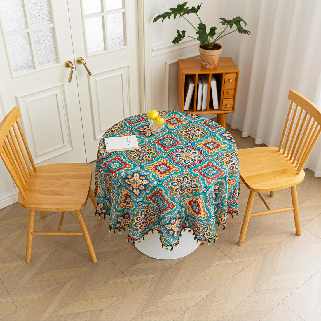 Bohemian Round Tablecloth – Add vibrant charm to your dining area with this colorful round tablecloth featuring intricate Moroccan-inspired patterns in bold turquoise, red, and yellow hues. Finished with playful multicolor tassels along the edge, it brings a lively boho flair to both indoor and outdoor dining. Perfect for kitchen tables, coffee nooks, or garden parties, this durable and eye-catching tablecloth is ideal for everyday use or special occasions.
