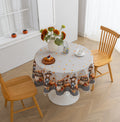 Autumn Harvest Round Tablecloth – Celebrate the cozy season with this charming round tablecloth featuring a delightful harvest design of pumpkins, sunflowers, barrels, and scarecrows. Accented with a black-and-white checkered border and finished with cream tassels, it brings a warm, festive touch to your dining space. Perfect for fall gatherings, Thanksgiving dinners, or seasonal décor, this durable and vibrant tablecloth adds rustic charm to any table setting.
