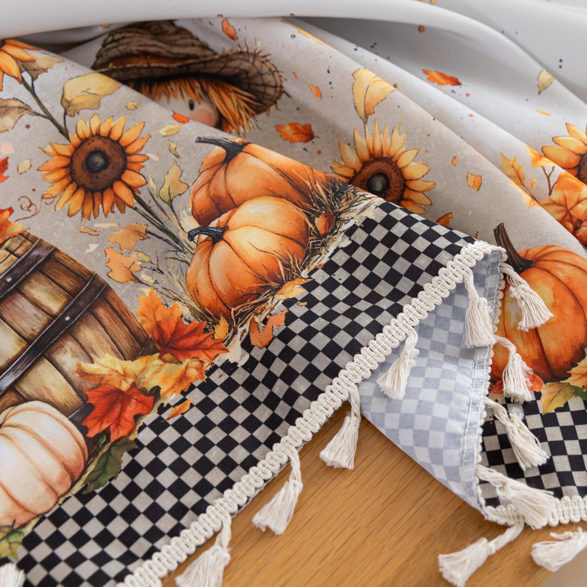 Autumn Harvest Round Tablecloth – Celebrate the cozy season with this charming round tablecloth featuring a delightful harvest design of pumpkins, sunflowers, barrels, and scarecrows. Accented with a black-and-white checkered border and finished with cream tassels, it brings a warm, festive touch to your dining space. Perfect for fall gatherings, Thanksgiving dinners, or seasonal décor, this durable and vibrant tablecloth adds rustic charm to any table setting.
