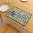 Charming floral woven placemat with blue and red blooms, perfect for adding a fresh, cottage-style touch to your dining table.