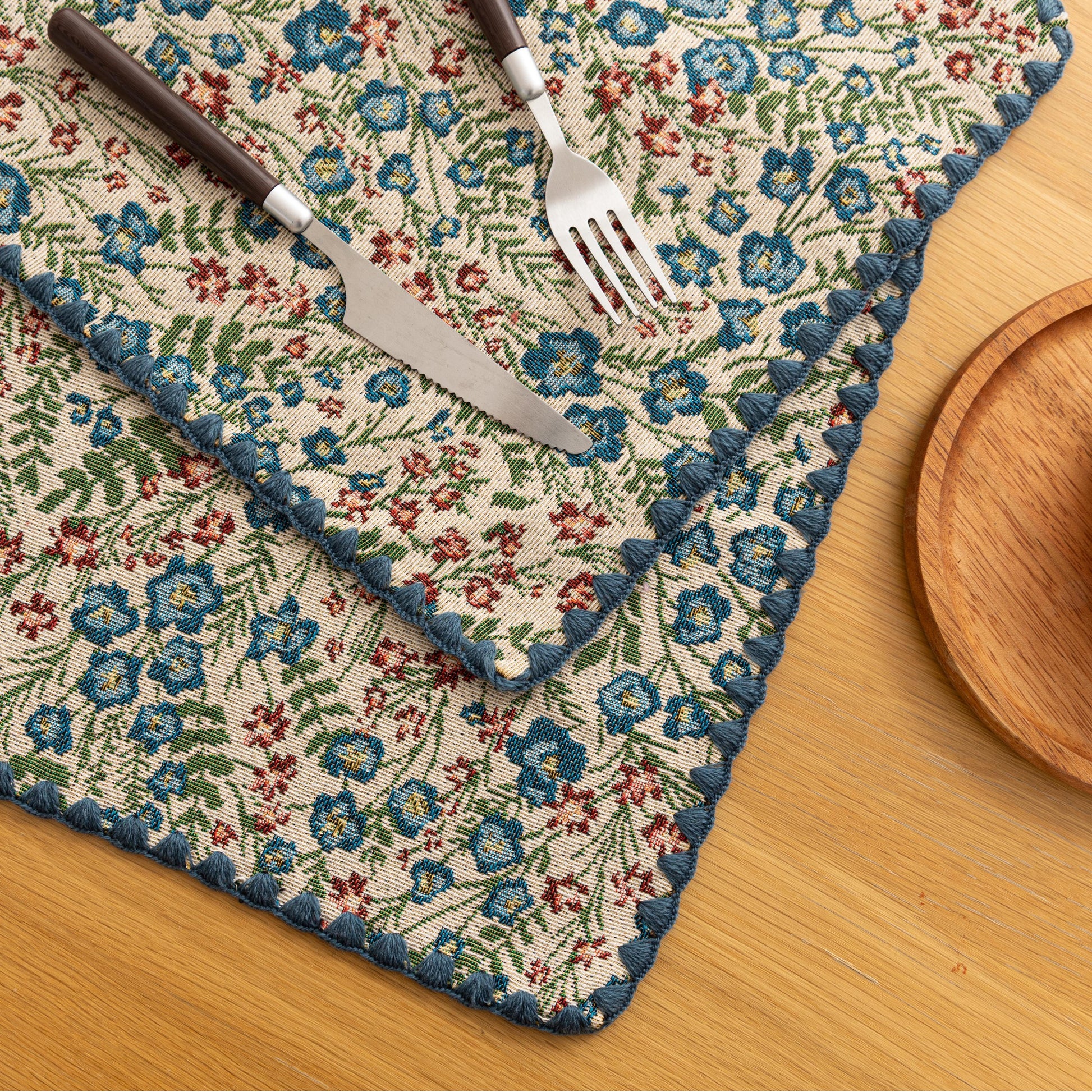 Charming floral woven placemat with blue and red blooms, perfect for adding a fresh, cottage-style touch to your dining table.
