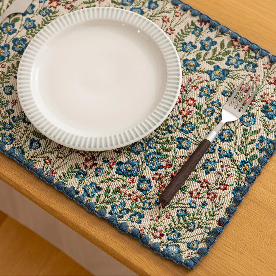 Charming floral woven placemat with blue and red blooms, perfect for adding a fresh, cottage-style touch to your dining table.