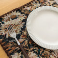 Elegant floral woven placemat in earthy tones, perfect for adding a classic, rustic charm to your dining table while offering durable protection.