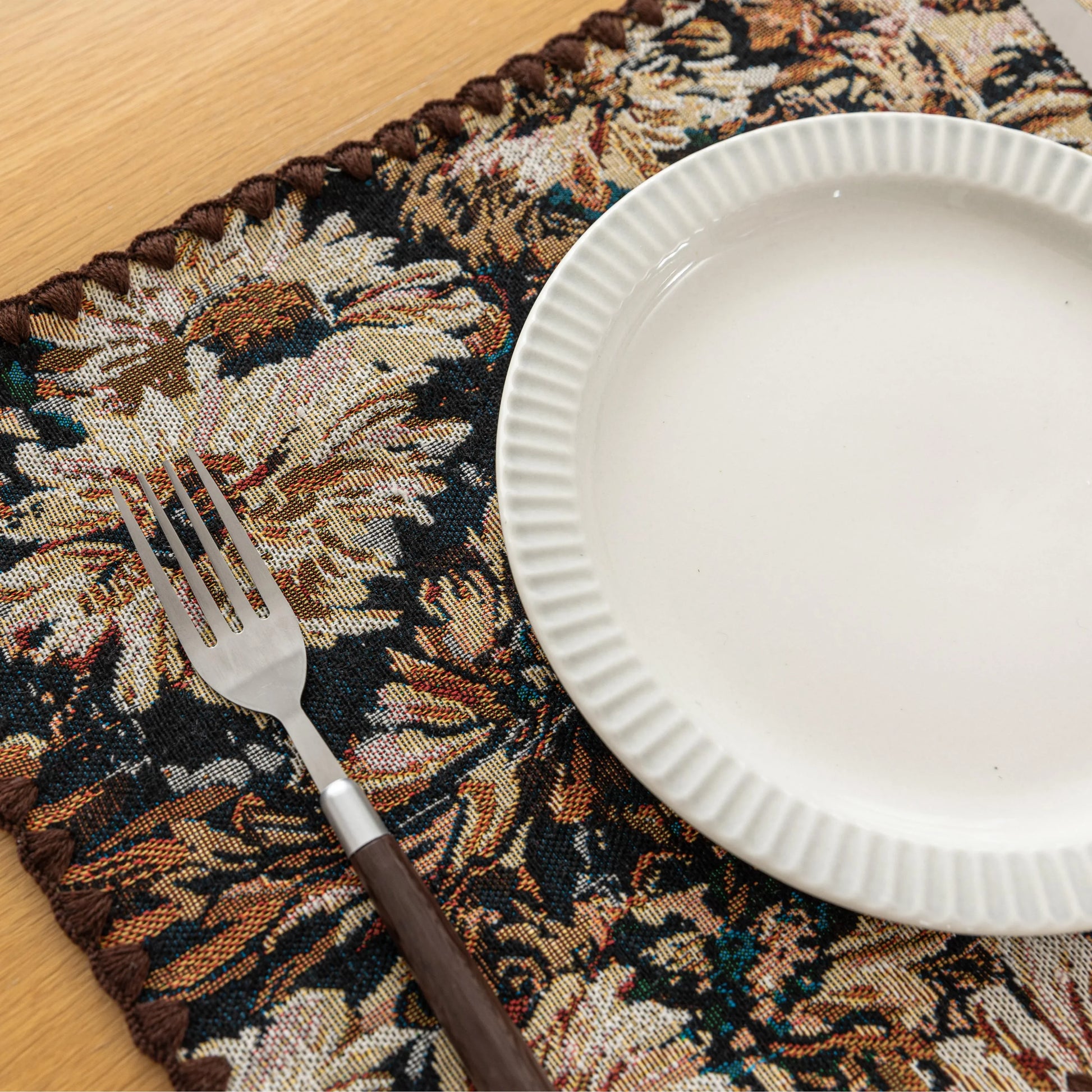 Elegant floral woven placemat in earthy tones, perfect for adding a classic, rustic charm to your dining table while offering durable protection.
