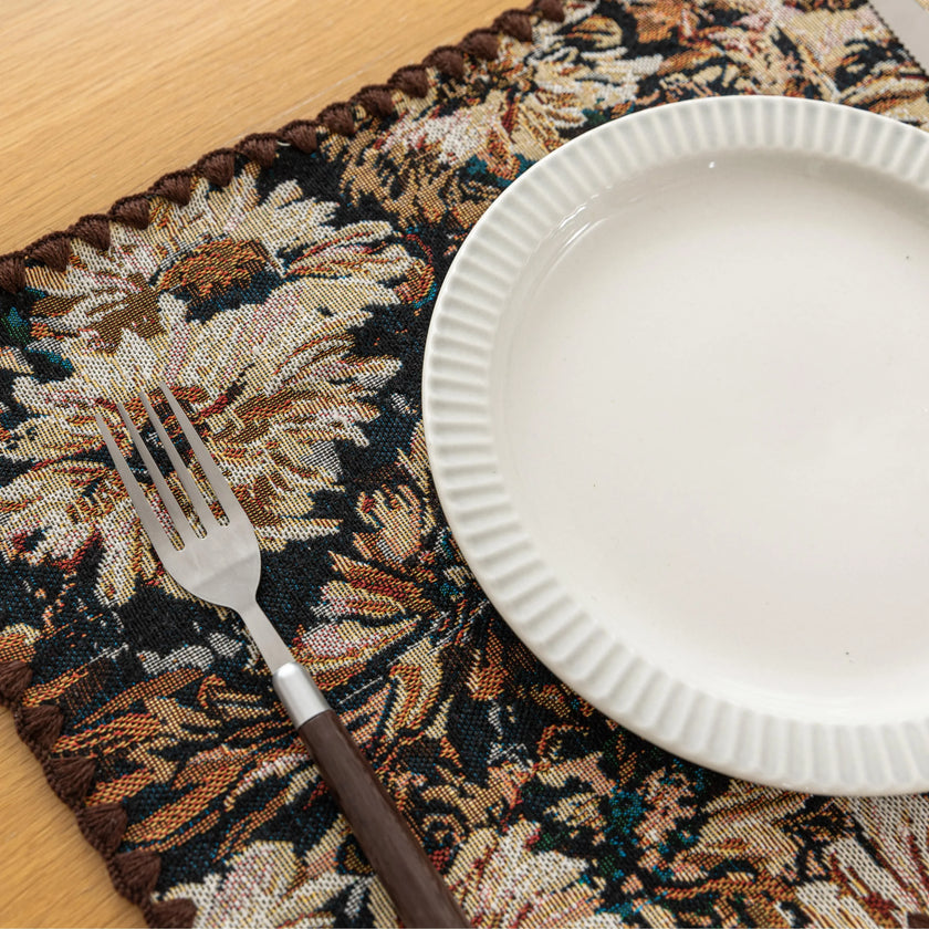 Elegant floral woven placemat in earthy tones, perfect for adding a classic, rustic charm to your dining table while offering durable protection.