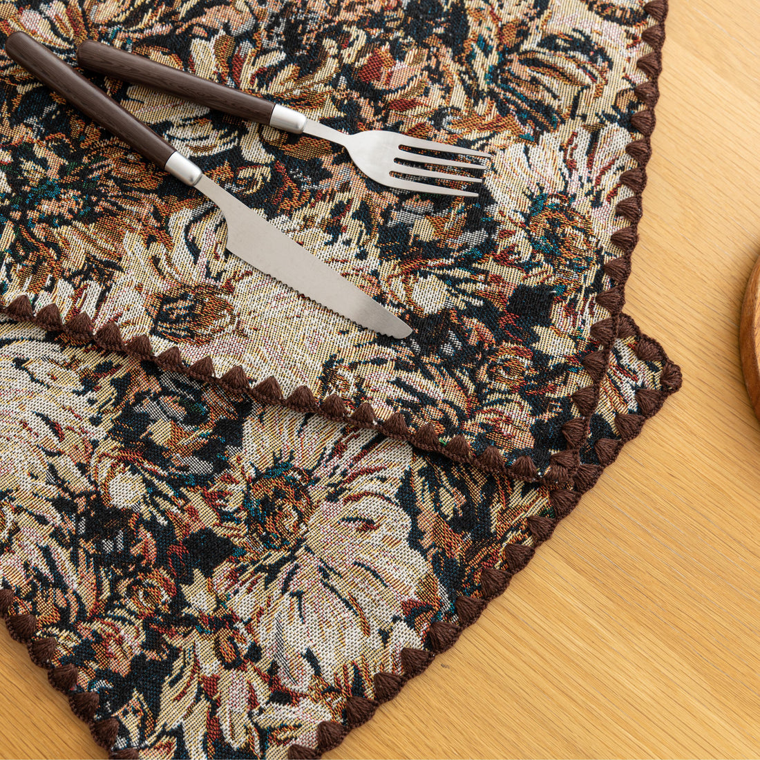 Elegant floral woven placemat in earthy tones, perfect for adding a classic, rustic charm to your dining table while offering durable protection.