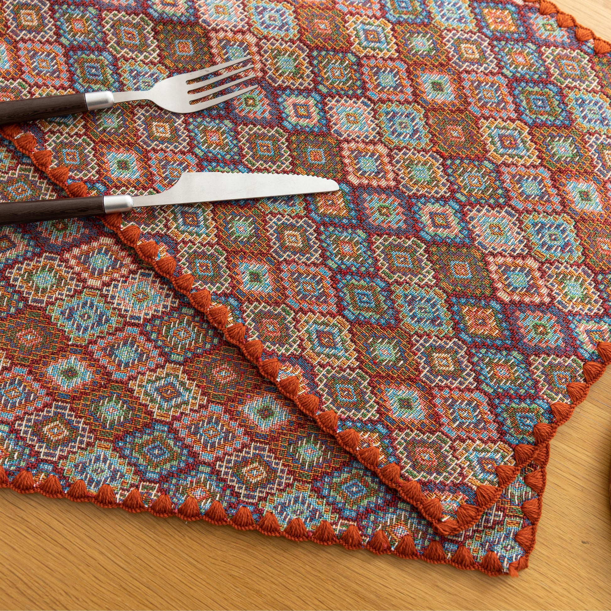 Colorful woven placemat with intricate diamond patterns, adding a vibrant boho touch while protecting your dining table.