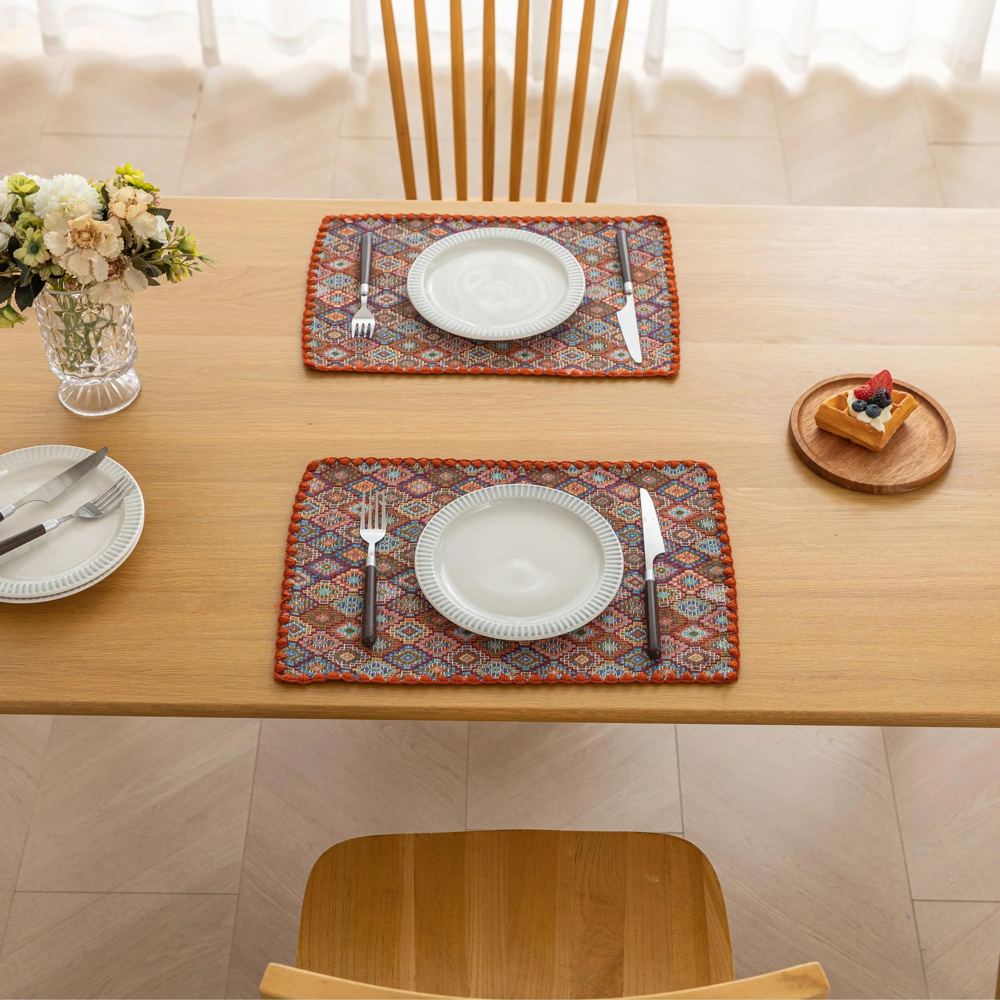 Colorful woven placemat with intricate diamond patterns, adding a vibrant boho touch while protecting your dining table.