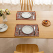 Colorful woven placemat with intricate diamond patterns, adding a vibrant boho touch while protecting your dining table.