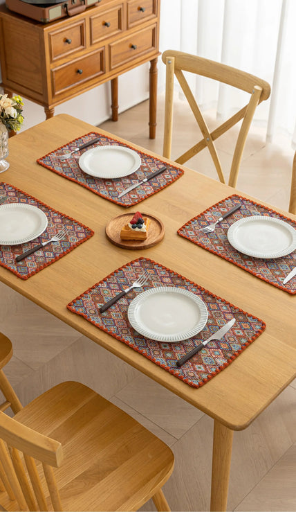 Colorful woven placemat with intricate diamond patterns, adding a vibrant boho touch while protecting your dining table.
