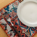 Bohemian woven placemat with vibrant geometric patterns, perfect for adding rustic charm and protecting your table during meals.