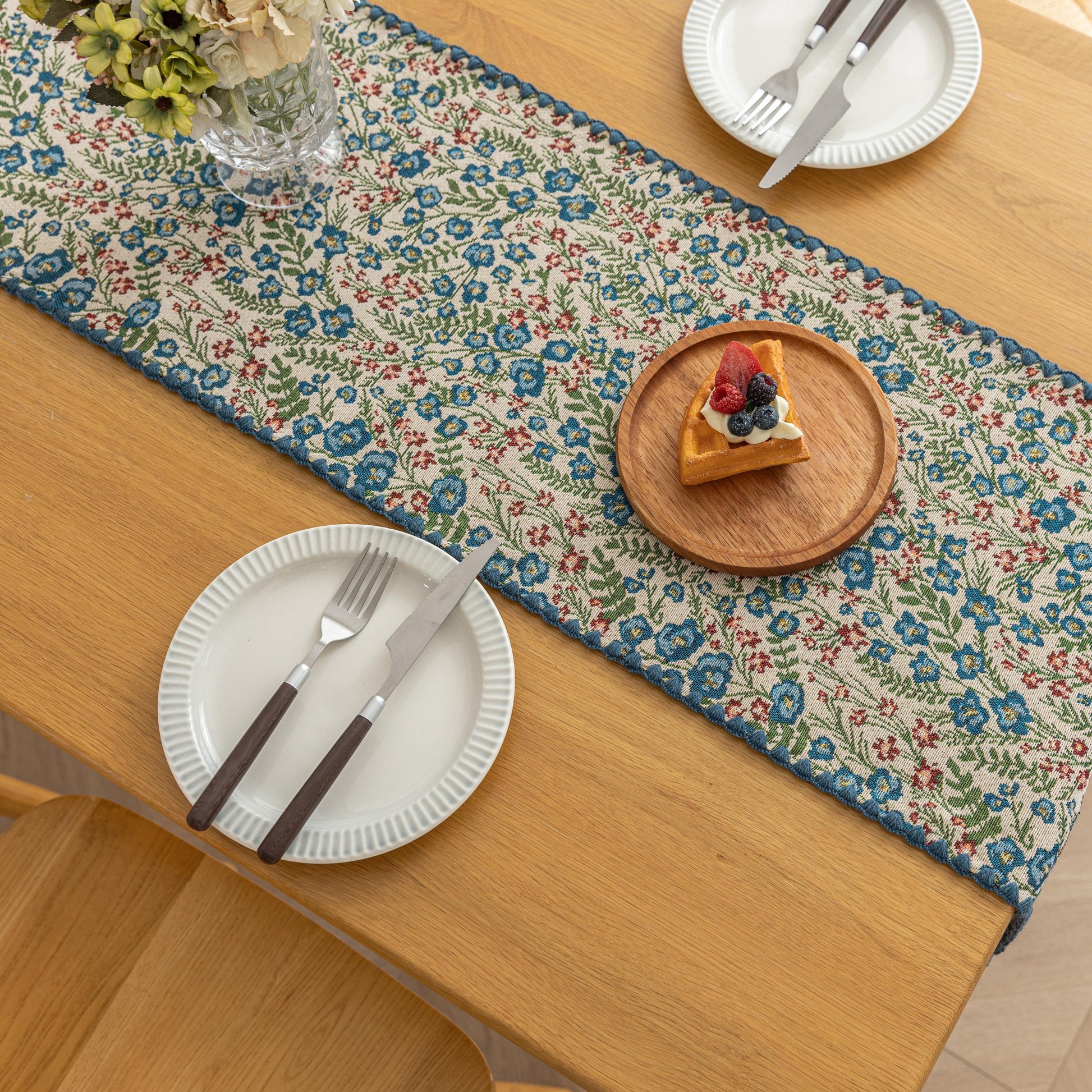 Vintage Floral Table Runner – Bring a touch of timeless charm to your dining space with this beautifully woven table runner featuring delicate blue and red floral patterns on a soft cream background. Accented with a subtle blue border, it adds a fresh and inviting feel to any table setting. Perfect for everyday meals, afternoon tea, or special occasions, this durable and stylish runner complements farmhouse, cottage, and classic home décor styles.
