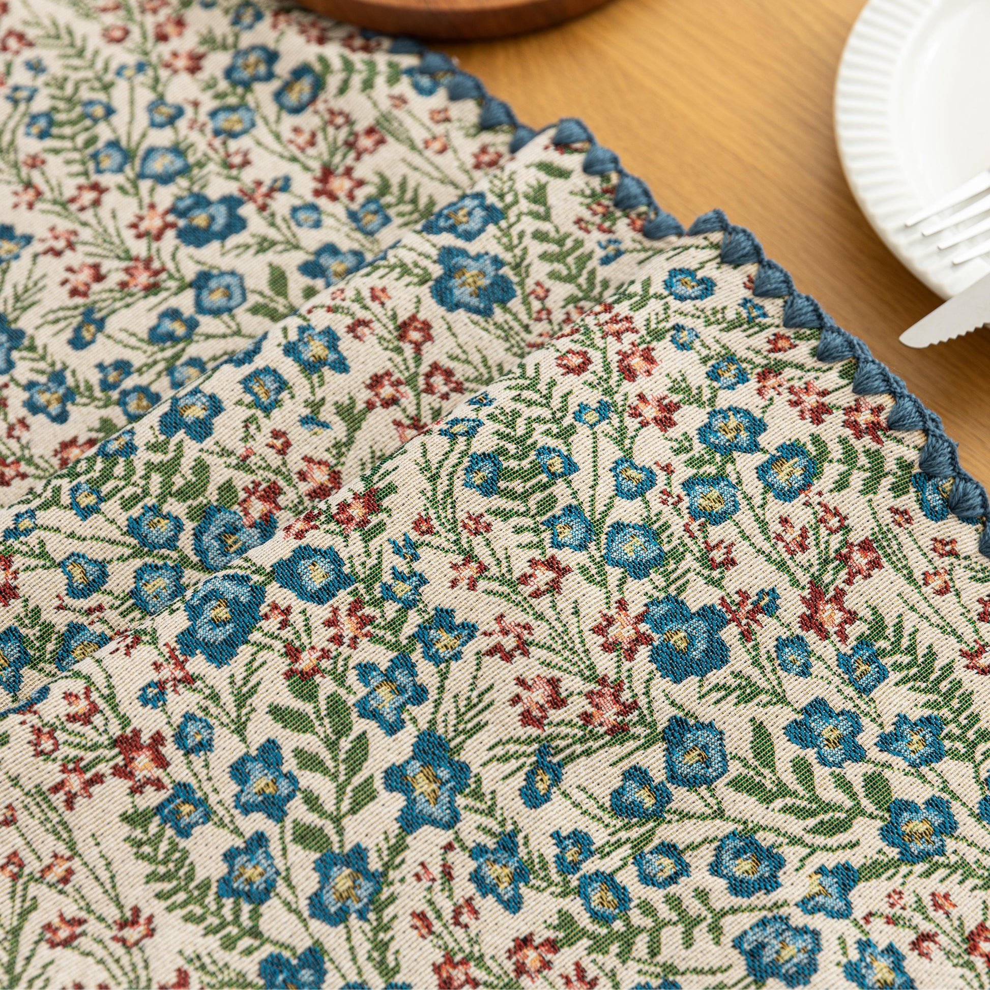 Vintage Floral Table Runner – Bring a touch of timeless charm to your dining space with this beautifully woven table runner featuring delicate blue and red floral patterns on a soft cream background. Accented with a subtle blue border, it adds a fresh and inviting feel to any table setting. Perfect for everyday meals, afternoon tea, or special occasions, this durable and stylish runner complements farmhouse, cottage, and classic home décor styles.
