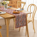 Colorful woven table runner with intricate diamond patterns, perfect for adding a vibrant boho touch to your dining or coffee table décor.