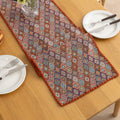 Colorful woven table runner with intricate diamond patterns, perfect for adding a vibrant boho touch to your dining or coffee table décor.