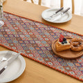 Colorful woven table runner with intricate diamond patterns, perfect for adding a vibrant boho touch to your dining or coffee table décor.