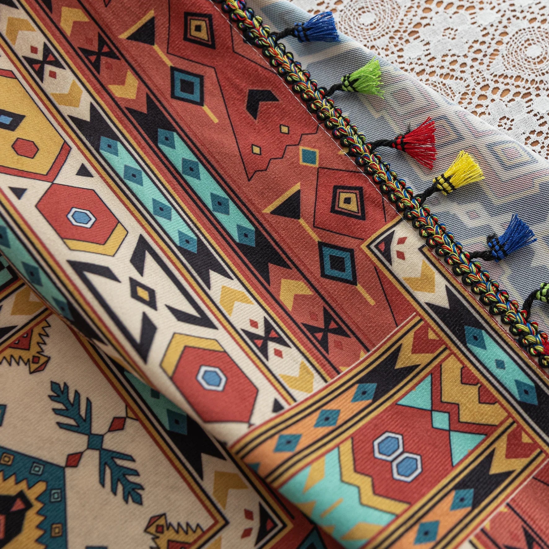 Colorful bohemian curtain with intricate tribal geometric patterns in rich earthy tones of red, beige, turquoise, and gold, accented with multicolor tassels — a perfect choice to add warmth, texture, and global-inspired charm to any room décor.